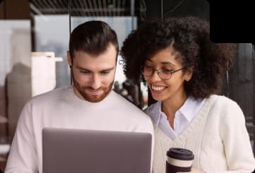 Dois profissionais trabalhando juntos em um laptop